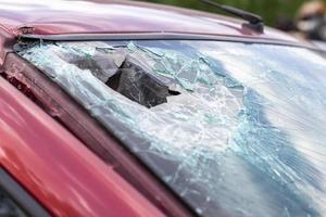 Close-up of a car with a broken windshield after a fatal crash. Consequence of a fatal car accident. Automobile danger. Reckless dangerous driving. Vehicle after an accident with a pedestrian. photo