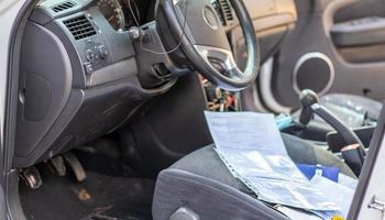 Close-up of the steering wheel of a car after an accident. The driver's airbags did not deploy. Soft focus. Broken windshield with steering wheel. Vehicle interior. Black dashboard and steering wheel. photo