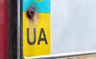 Part of the Ukrainian license plate on the bumper close-up. The symbol of nationality on the background of the colors of the flag. Individual registration plate of the vehicle. photo