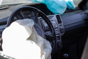 The driver's airbag deployed on the steering wheel of the car after the collision. Deflated airbags after flared deployment. The airbag deployed. Car after an accident. Safety device in the car. photo