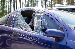 Criminal incident. Breaking into a car parked on the street. Broken side glass and the passenger compartment behind it. A crime committed by a thief, stealing things. Car after an accident. photo