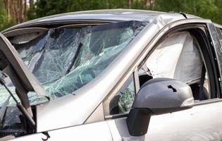 Close-up of a car with a broken windshield after a fatal crash. Consequence of a fatal car accident. Automobile danger. Reckless dangerous driving. Vehicle after an accident with a pedestrian. photo