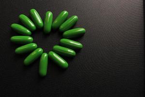 Shallow focus closeup shot of green pills arranged in a heart shape photo