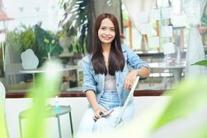 Happy Asian woman holding a coffee shop photo