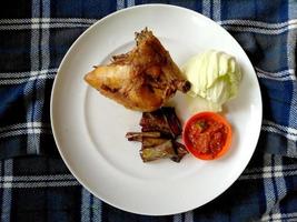 Ayam Goreng Lalapan or Fried Chicken serve with fresh vegetables and sambal. Indonesian culinary food photo