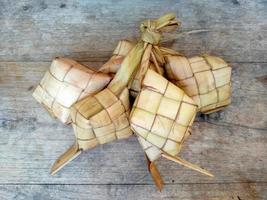 Tipat or Ketupat or Rice Dumpling On Wooden Background photo