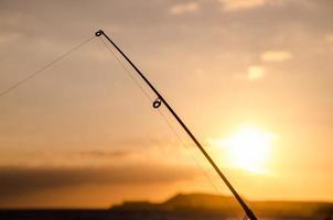 silueta de caña de pescar pescador foto