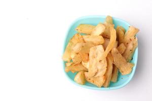 selective focus of fried cassava in blue bowl on white background, copy space, texture, Indonesian food. photo