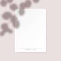 White vertical paper blank with eucalyptus leaves shadow on pastel pink background.