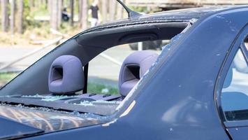 A car after an accident with a broken rear window. Broken window in a vehicle. The wreckage of the interior of a modern car after an accident, a detailed close-up view of the damaged car. photo