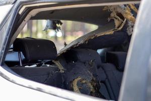 un coche después de un accidente con un cristal trasero y lateral roto, vista desde la ventana trasera. ventana rota en un vehículo. los restos de la berlina, un primer plano detallado del coche dañado. foto