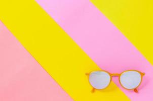 Yellow sunglasses isolated on colorful background. photo