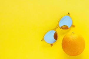 Orange fruit and yellow sunglasses for summer time. photo