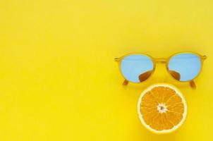 Slice orange fruit and yellow sunglasses. photo