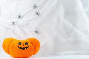 Pumpkin toy putting at spiders cobweb background photo