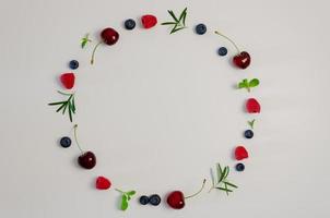 hojas frescas de cereza, arándano, frambuesa, menta y romero en la parte superior con fondo blanco para un concepto de comida saludable. foto
