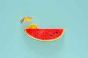 Red watermelon with slice lemon and cocktail umbrella photo