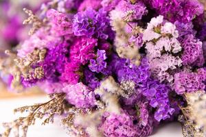 Close up shot of violet and colorful small flowers arranged in bouquet. photo