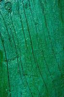vieja pintura verde agrietada en una tabla de madera. pancarta vertical foto