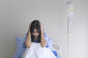 A despondent Asian woman patient. Following the doctor's declaration that the cancer was nearing the end of its course. photo