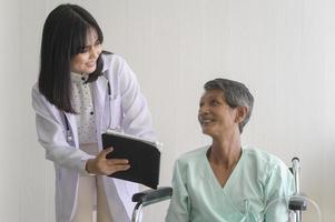 Doctor helping senior patient man moving to wheelchairs at hospital, health care and medical concept photo