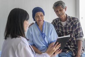 Cancer patient woman wearing head scarf after chemotherapy consulting and visiting doctor in hospital.. photo