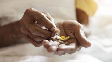 pastillas en manos de un anciano. vejez dolorosa. cuidando la salud de los ancianos foto