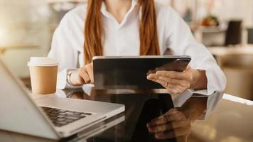 mano de mujer de negocios usando teléfonos inteligentes, pagos de tabletas y compras en línea con tarjeta de crédito, omnicanal, computadora de teclado de acoplamiento de tableta digital en la oficina foto