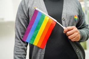 mujer asiática con bandera del arco iris, derechos de símbolos lgbt e igualdad de género, mes del orgullo lgbt en junio. foto