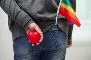 mujer asiática con bandera del arco iris, derechos de símbolos lgbt e igualdad de género, mes del orgullo lgbt en junio. foto