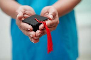 Asian woman doctor holding graduation hat in hospital, Medical education concept. photo