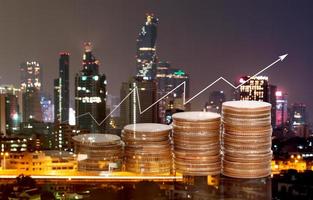 Double exposure Image with stacked coins and cityscape for economic growth and business concept photo