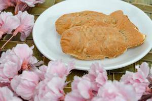 Taiyaki cakes in white dish with cherry blossom,Japanese confectionery photo