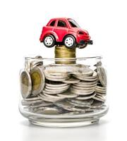 coins in glass bottle and car on white background,business saving and investment concept photo