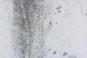 Texture of a concrete wall with cracks and scratches which can be used as a background photo