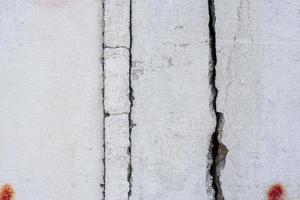 Texture of a concrete wall with cracks and scratches which can be used as a background photo