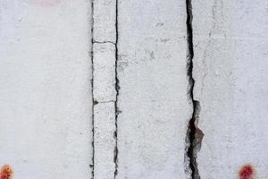 Texture of a concrete wall with cracks and scratches which can be used as a background photo