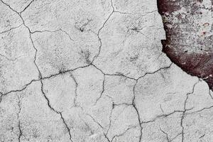 Texture of a concrete wall with cracks and scratches which can be used as a background photo