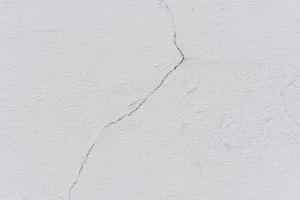 Texture of a concrete wall with cracks and scratches which can be used as a background photo