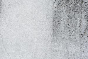 Texture of a concrete wall with cracks and scratches which can be used as a background photo