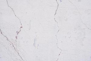 Texture of a concrete wall with cracks and scratches which can be used as a background photo