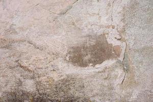 Texture of a concrete wall with cracks and scratches which can be used as a background photo