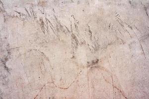 Texture of a concrete wall with cracks and scratches which can be used as a background photo