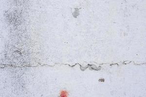 Texture of a concrete wall with cracks and scratches which can be used as a background photo