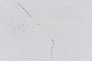 Texture of a concrete wall with cracks and scratches which can be used as a background photo