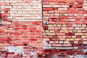 Texture of a brick wall with cracks and scratches which can be used as a background photo