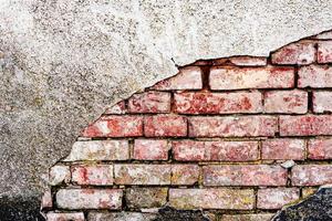 Texture of a brick wall with cracks and scratches which can be used as a background photo