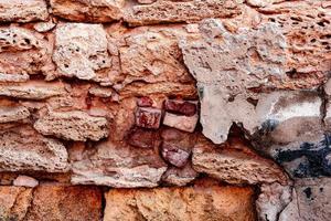 Texture of a brick wall with cracks and scratches which can be used as a background photo