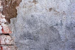 Texture of a concrete wall with cracks and scratches which can be used as a background photo