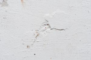 Texture of a concrete wall with cracks and scratches which can be used as a background photo